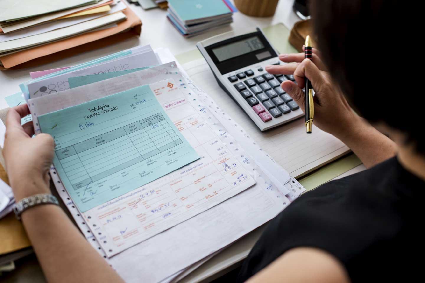 Mujer revisando papeleo y facturas en la oficina